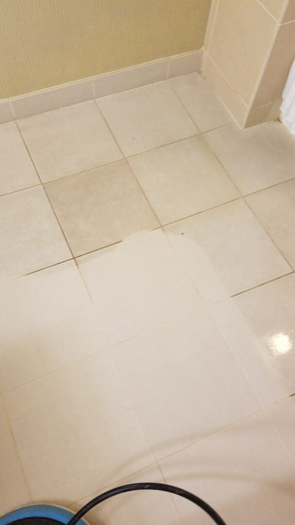 A gallery bathroom with a white tile floor and a vacuum cleaner.