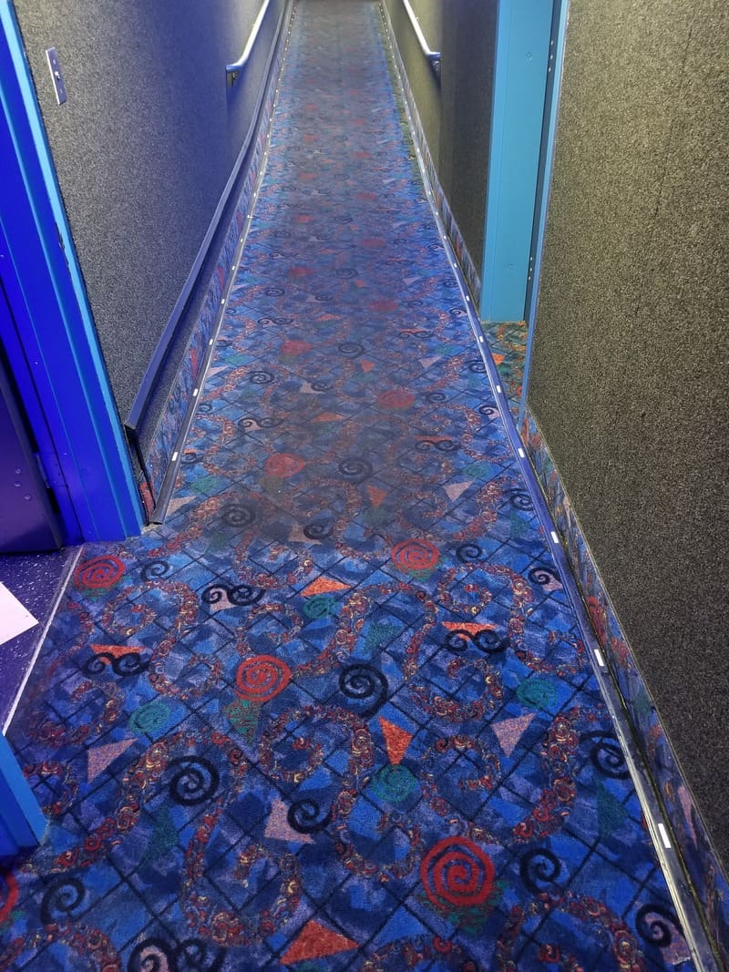 A blue carpeted gallery with blue walls.