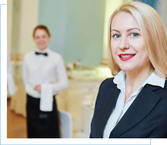 A woman is standing in front of a staffing group of waiters and waitresses.