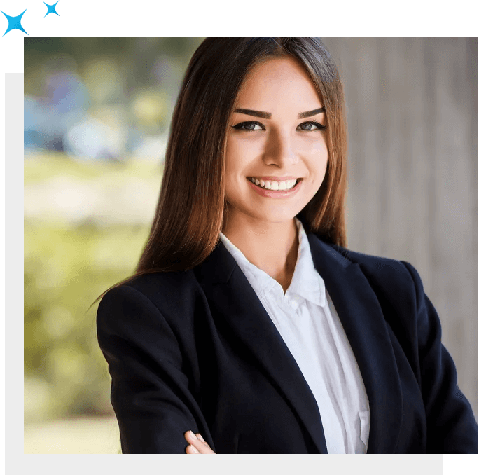 A professional woman in a business suit smiling with her arms crossed.